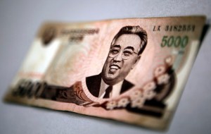 North Korean leader Kim Il-sung is seen on this 5000 North Korea won banknote in this photo illustration taken in Shanghai May 23, 2013. Chinese currency and U.S. dollars are being used more widely than ever in North Korea instead of the country's own money. The use of dollars and Chinese yuan, or renminbi, has accelerated since a revaluation of the North Korean won in 2009 wiped out the savings of millions of people, said experts on the country, defectors and Chinese border traders. The black market exchange rate for this 5000 North Korean won banknote is equivalent to $0.65, while the official North Korean exchange rate stands at more than $65. To match Insight KOREA-NORTH/MONEY REUTERS/Carlos Barria (CHINA - Tags: POLITICS BUSINESS) - RTX109LL